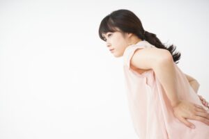 腰の痛みを感じている女性